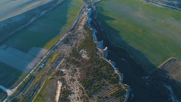 Luchtfoto op een berg klif in de buurt van de groene valleien en de snelweg in een zonnige dag. Beelden. Prachtige zomer landschap — Stockvideo