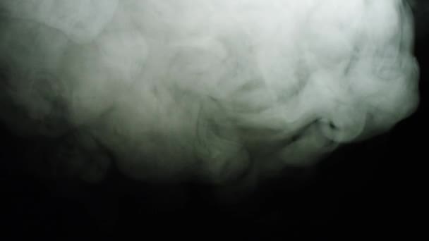 Fumaça em fundo preto. Imagens de stock. Riachos finos de nuvens de fumaça branca se espalhando em fundo isolado preto — Vídeo de Stock