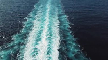 Deniz ya da okyanus yüzeyindeki güzel bir trenin havadan görünüşü. Hız teknesinin arkasında. Hisse. Büyük bir gemi tarafından okyanusta uyanmak.