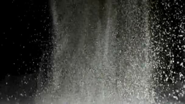黒い背景に隔離された白い粉のスプラッシュ。ストック映像。白い抽象的な雪が投げ出されるクローズアップ. — ストック動画