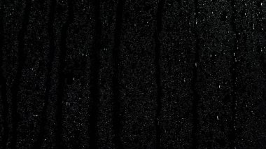 Siyah arka plan, pencere yoğuşması üzerine inen siyah cam curface üzerinde birçok küçük damla. Stok görüntüleri. Siyah pencereye püskürtülen su için yakın çekim.