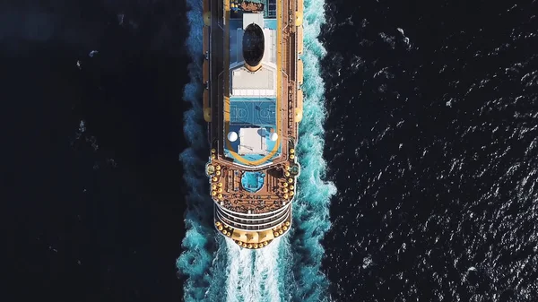 Vista de pájaro vista superior de gran crucero en aguas azules profundas en un día soleado, concepto de lujo. Acciones. Vista aérea de crucero de lujo con piscinas y campo de baloncesto a bordo en el océano azul . —  Fotos de Stock
