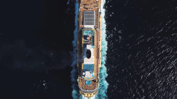 Vista dall'alto della nave da crociera di grandi dimensioni in acque blu intenso in una giornata di sole, concetto di lusso. Azioni. Vista aerea del lussuoso transatlantico con piscine e campo da basket a bordo nell'oceano blu . — Foto Stock