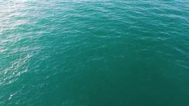 Вид с воздуха на спокойную морскую или океанскую водную поверхность, природный фон. На складе. Вид сверху на чистую океанскую воду с солнечными вспышками . — стоковое видео