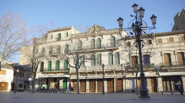 Kafeler ve akşamları yürüyen insanlar ile şehir meydanı. Madde. Sonbaharda kafe ve ağaçlarla Avrupa evlerinin arka planında yürüyen insanların kentsel görünümü