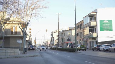 Yerleşim bölgesinde şehir yolunun güzel görünümü. Madde. Mavi gökyüzüne karşı güneşin akşam ışınları yolda az trafik ile şehir ve yol evleri aydınlatmak