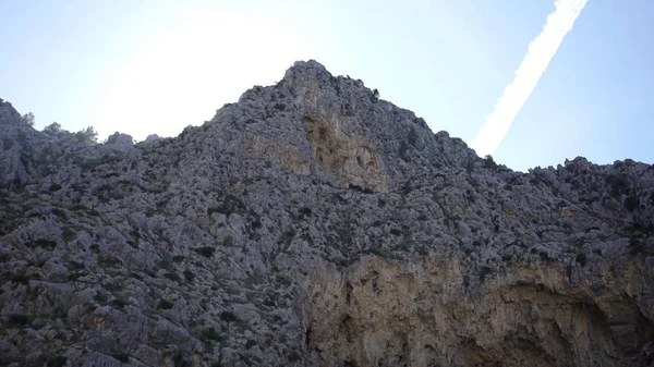 Gökyüzünün arka planda kayalık dağ zirvesinde aşağıdan bakın. Madde. Açık yaz gününde tümsek ve çıkıntılar ile Doğal doğal kayalık dağlar