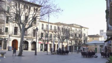 Kafeler ve akşamları yürüyen insanlar ile şehir meydanı. Madde. Sonbaharda kafe ve ağaçlarla Avrupa evlerinin arka planında yürüyen insanların kentsel görünümü