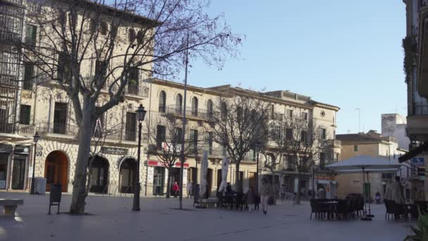 Kafeler ve akşamları yürüyen insanlar ile şehir meydanı. Madde. Sonbaharda kafe ve ağaçlarla Avrupa evlerinin arka planında yürüyen insanların kentsel görünümü — Stok video