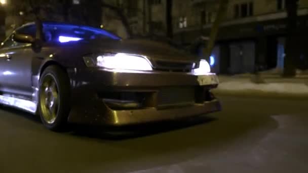 Botten bild av cool bilkörning på Night City. Åtgärder. Glänsande mörkt guld finish med glitter på bilkörning genom Night City och mousserande från ljus av lyktor — Stockvideo