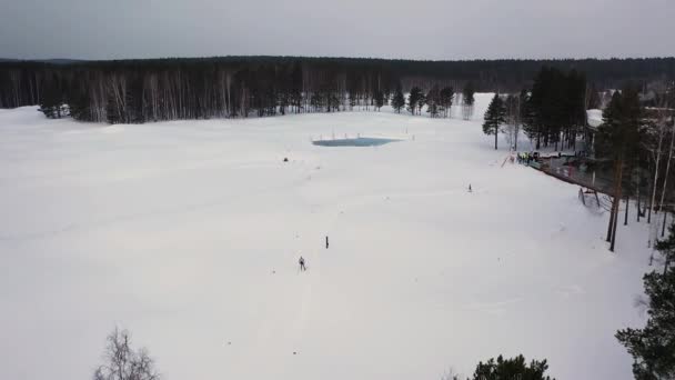 Vue aérienne de la station de ski avec une piste de ski et un homme participant à la compétition d'hiver, Russie. Des images. Belle nature, forêt de pins et ciel gris lourd .