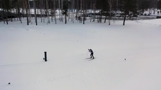 Cross country esqui técnica de patinação praticada pelo homem vestido com uniforme especial, conceito de jogos de esportes de inverno. Filmagem. Jovem que participa no campeonato de esqui de inverno . — Vídeo de Stock