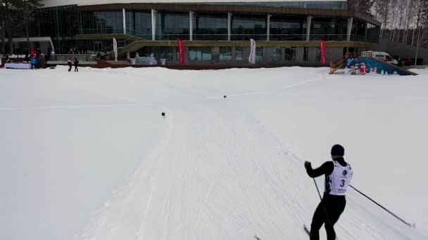 ●フィニッシュラインに来るユニフォームを着たスキーヤーのマウント、スポーツコンセプト。映像。男スキースケート彼の最後のラップ、スキー選手権. — ストック動画