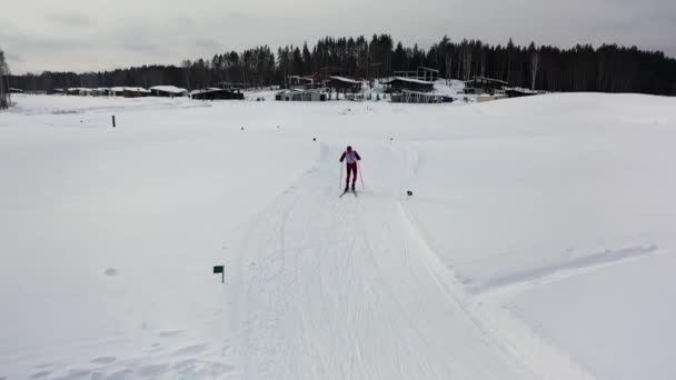 겨울 숲, 스포츠 대회 컨셉에서 남자 스키어 스케이팅을 위한 공중. 푸티지. 겨울 대회에 참가하는 스키 트랙에서 스키 유니폼을 입은 남자. — 비디오