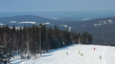 Kış tatili için spor tesisi panoramik görünümü, sağlıklı yaşam tarzı kavramı. Görüntü. İnsanlar snowboard ve kış orman arka plan üzerinde tepeden aşağı kayak.