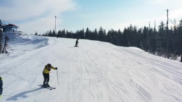 화창한 날, 위험한 스포츠 개념에서 스키와 스노우 보드의 그룹과 눈 덮인 슬로프에 대한 공중. 푸티지. 겨울 스포츠를 하는 남성과 여성. — 비디오