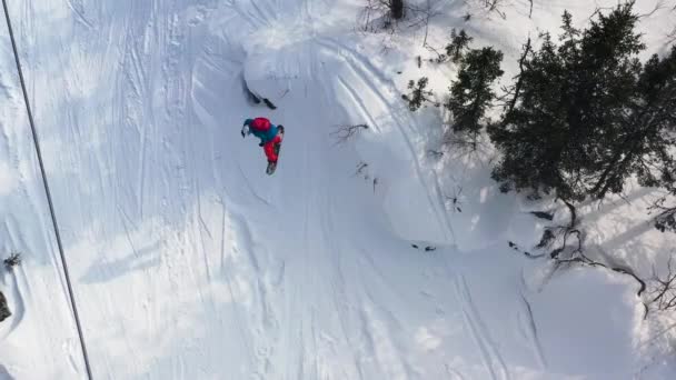 Aerial widok z góry snowboardzista jazda z proszku śnieg wzgórzu bardzo szybko i spada. Materiału. Man granicy skoki ze wzgórza i upadki, koncepcja sportu. — Wideo stockowe