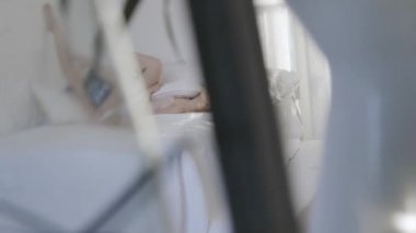 Genç sarışın kadın gün ışığında yatakta yatıyor. Başla. Sabahları beyaz yatağa uzanmış erotik iç çamaşırı giyen güzel, genç, sarışın kadın mankeni.