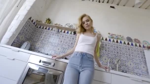 Расслабленная сексуальная блондинка позирует на кухне по утрам. Начали. Сексуальная молодая блондинка на кухне дома — стоковое видео