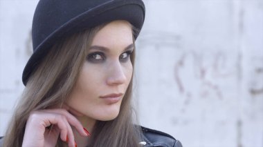 Şık genç kadının açık hava moda portresi eğlenip, duygusal bir yüz, gülme, kameraya bakma. Eylem. Siyah şapka. İlkbahar veya sonbahar kıyafeti