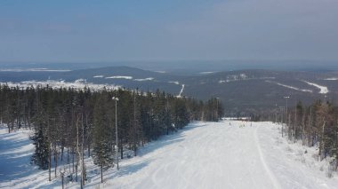 Kış tatili için spor tesisi panoramik görünümü, sağlıklı yaşam tarzı kavramı. Görüntü. İnsanlar snowboard ve kış orman arka plan üzerinde tepeden aşağı kayak.