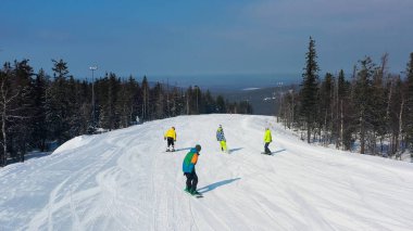 Çam ormanı aeria modern kayak tesisi, yukarıdan görünümü. Görüntü. Genç grup insan snowboard ve karlı yamaç aşağı kayak.