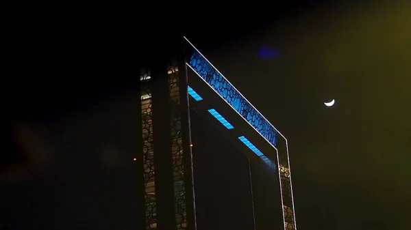 Edifício de molduras à noite em Dubai, Emirados Árabes Unidos, conceito de arquitetura. Estoque. Arco bonito à noite em luzes brilhantes, vista inferior . — Fotografia de Stock