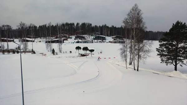 Vue aérienne de la station de ski avec une piste de ski et un homme participant à la compétition d'hiver, Russie. Des images. Belle nature, forêt de pins et ciel gris lourd . — Photo