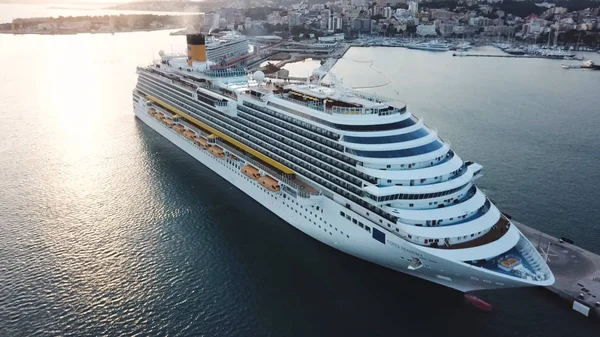 Beautiful white cruise liner in the bay, aerial view. Stock. Picturesque view of a harbor, sea shore and big cruise ship with people on board. — Stock Photo, Image