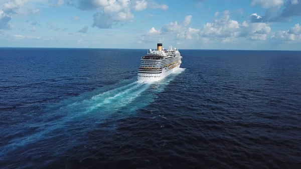 Atrás del crucero y su hermosa estela en la superficie azul del mar, el paisaje marino. Acciones. Vista aérea de un hermoso crucero blanco en un día soleado sobre un fondo azul nublado . —  Fotos de Stock