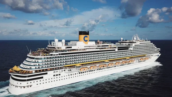 Luxury large cruise ship sailing across the Indian ocean against bright cloudy sky on the background. Stock. Aerial side view of a white magnificent liner under the blue sky. — Stock Photo, Image