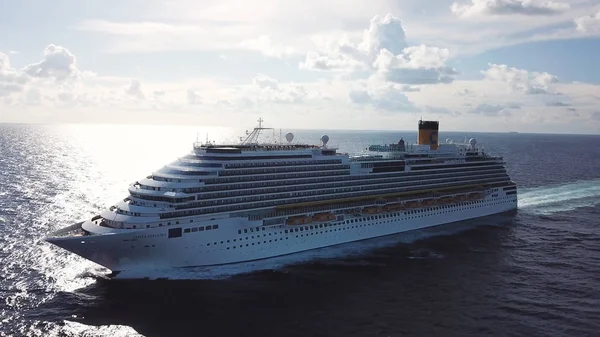 Luxo grande navio de cruzeiro navegando através do oceano Índico contra o céu nublado brilhante no fundo. Estoque. Vista lateral aérea de um forro magnífico branco sob o céu azul . — Fotografia de Stock