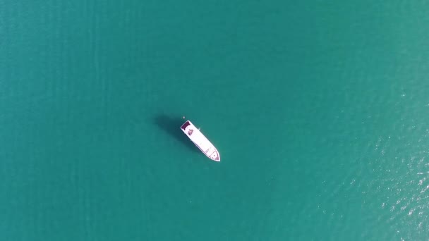 Aerial drone bird eye top view of white beautiful yacht in turquoise clear water of Greece. Acciones. Fondo de agua turquesa con barco blanco, paisaje marino de verano . — Vídeo de stock