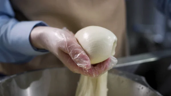 Zbliżenie na ręce w rękawiczkach do gotowania przygotowujących ser mozzarella, koncepcja żywności. Ramki. Pracownik fabryki sera produkującego mozzarellę. — Zdjęcie stockowe