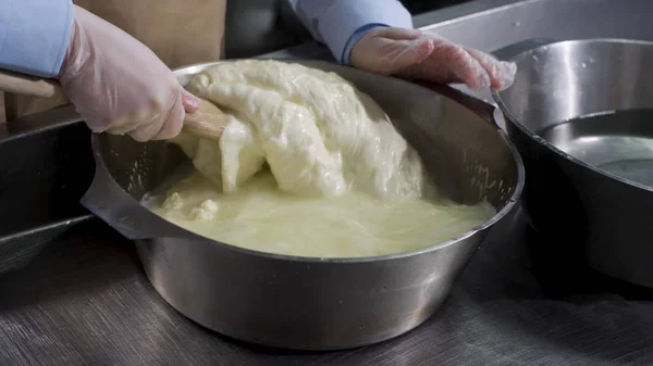 Una preparación casera de queso mozzarella con leche fresca, concepto de comida italiana. Una trampa. Cerrar para las manos en guantes de cocina haciendo mozzarella de la manera tradicional . — Foto de Stock