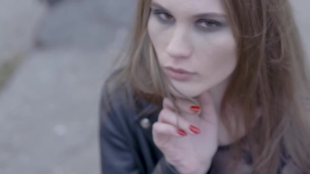 Stylish woman looking at camera outdoors in the street. Action. The face of a satisfied young woman in the city — Stock Video