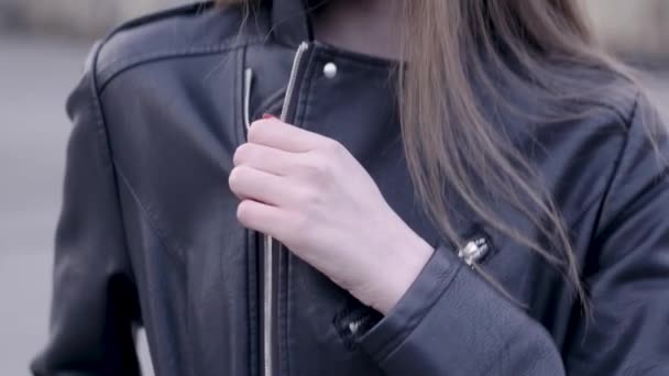 Frau trägt trendige schwarze Lederjacke mit Reißverschluss. Aktion. junge Frau reißt Lederjacke — Stockvideo