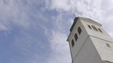 Güneşli bir günde kilise kulesi. Eylem. Mavi gökyüzünün arka planda Beyaz Kilise çan kulesi