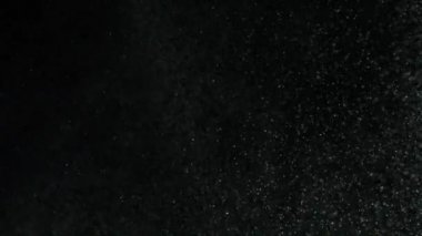 Siyah arka planda uçan gri toz parçacıklarının yakın çekim görünümü. Stok görüntüleri. Beyaz ve siyahın kontrastı