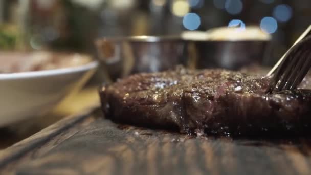 Heißes saftiges Steak mit Messer auf einem Holzbrett in Nahsicht geschnitten. mittlerer seltener Grad an Steak-Dondness — Stockvideo