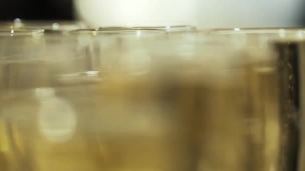 Vista borrosa de cerca de las copas de champán con un delicioso champán fresco o vino espumoso blanco en una mesa. Acción. Fiesta de oficina — Vídeos de Stock