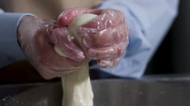 Elleriyle mozzarella kesen bir peynircinin elleri için kapatın, geleneksel gıda konsepti. Çerçeve. Lezzetli İtalyan peyniri yapma süreci.