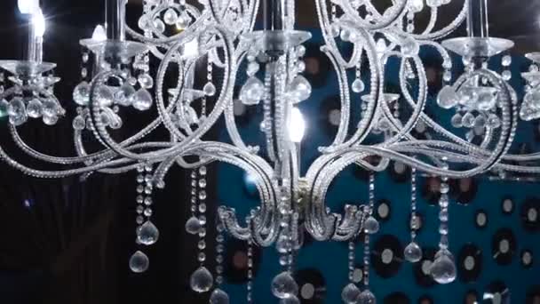 Lustre vintage. Clipe. Close-up em cristal de lustre contemporâneo, é um acessório de luz ornamental ramificado projetado para ser montado em tetos ou paredes — Vídeo de Stock