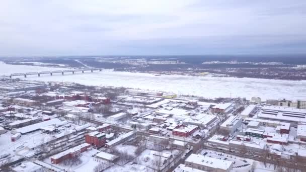 Aerial view frozen river winter landscape. Clip. Top view of the city with the frozen river in winter — Stock Video