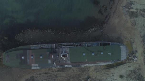 Vista aérea de un gran barco vintage de pie sobre los guijarros rodeados de agua de mar contra las colinas de montaña y el cielo azul. Antiguos buques de navegación marítima — Vídeo de stock