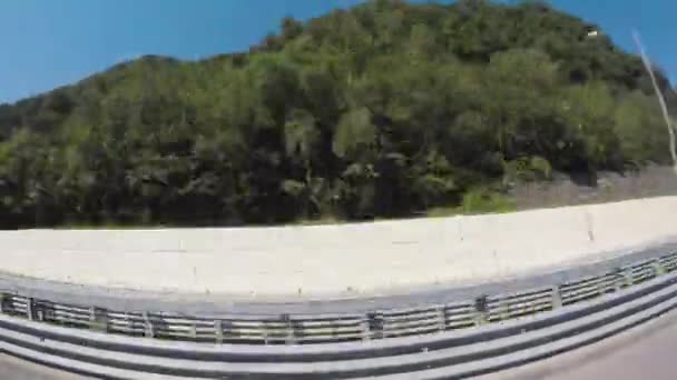 Vista dal finestrino dell'auto su colline verdi e veicolo di guida su una strada parallela e cielo blu, Israele, effetto fisheye. Scena. Paesaggio verde e fresco della vegetazione in collina, time lapse . — Video Stock