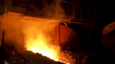 Çelik işletme, ağır sanayi konsepti kırmızı, sıcak erimiş demir için yakın. Stok görüntüleri. Dökümhanede oluk için birçok uçan ışıltılar ile akan erimiş çelik.