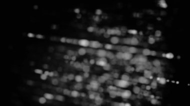 Küçük dairelerin dönen ışınları ile bulanık monokrom arka plan, sorunsuz döngü. Animasyon. Siyah arka planda beyaz ve gri nokta sıraları döndürme.