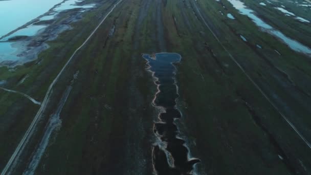 Flygbild av grön bit mark med vägar och träsk nära floden eller sjön i början av våren. Skott. Pittoresk utsikt från ovan — Stockvideo