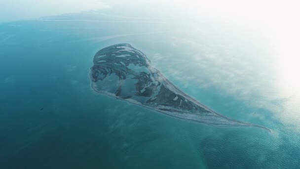 Niesamowity widok z lotu ptaka w kształcie twarzy z dużymi jeziorami i ciemnobrązowej ziemi w środku morza w słoneczny dzień. Strzał. Samotna wyspa w morzu — Wideo stockowe